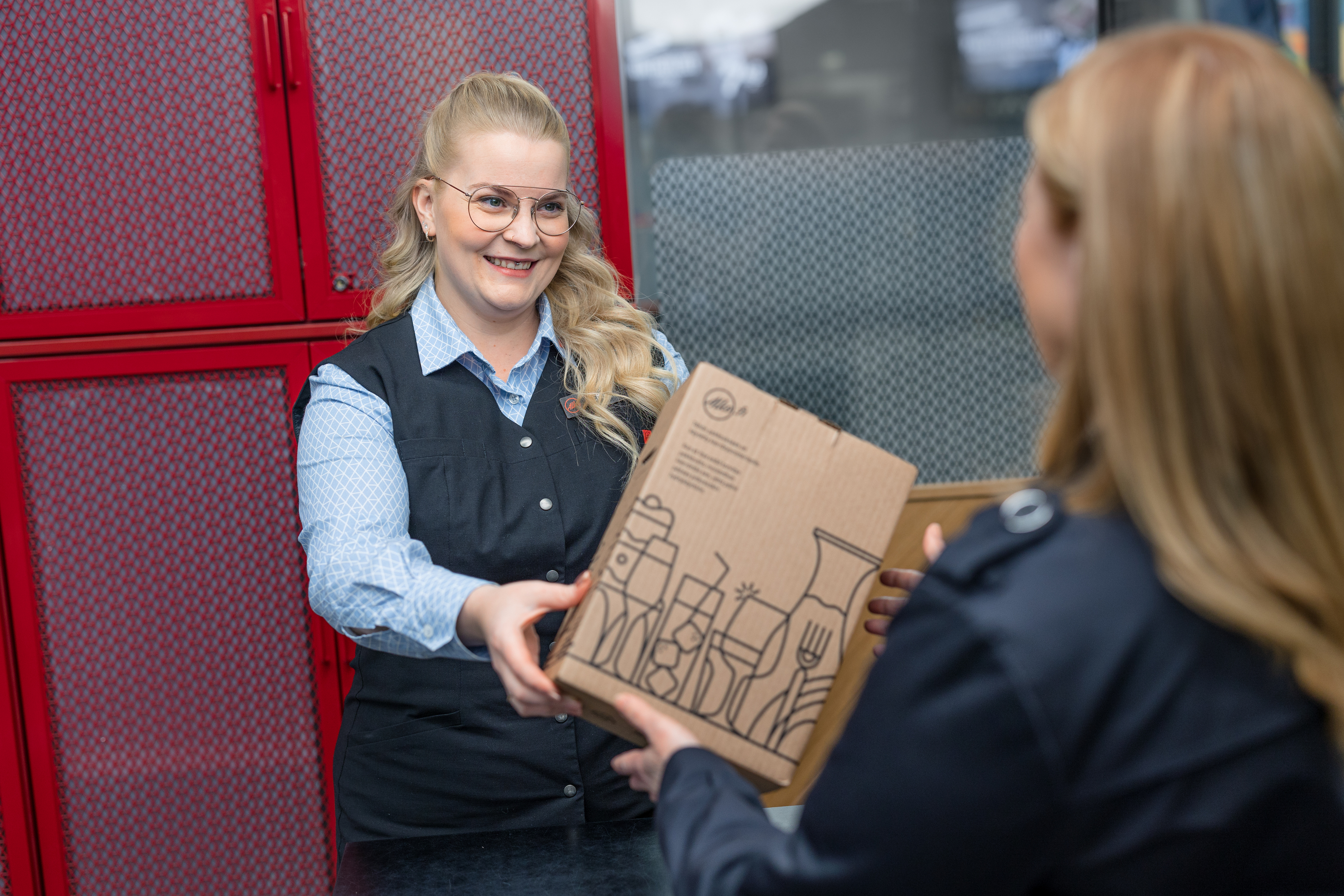 The seller hands out the e-commerce package to the customer in the store.