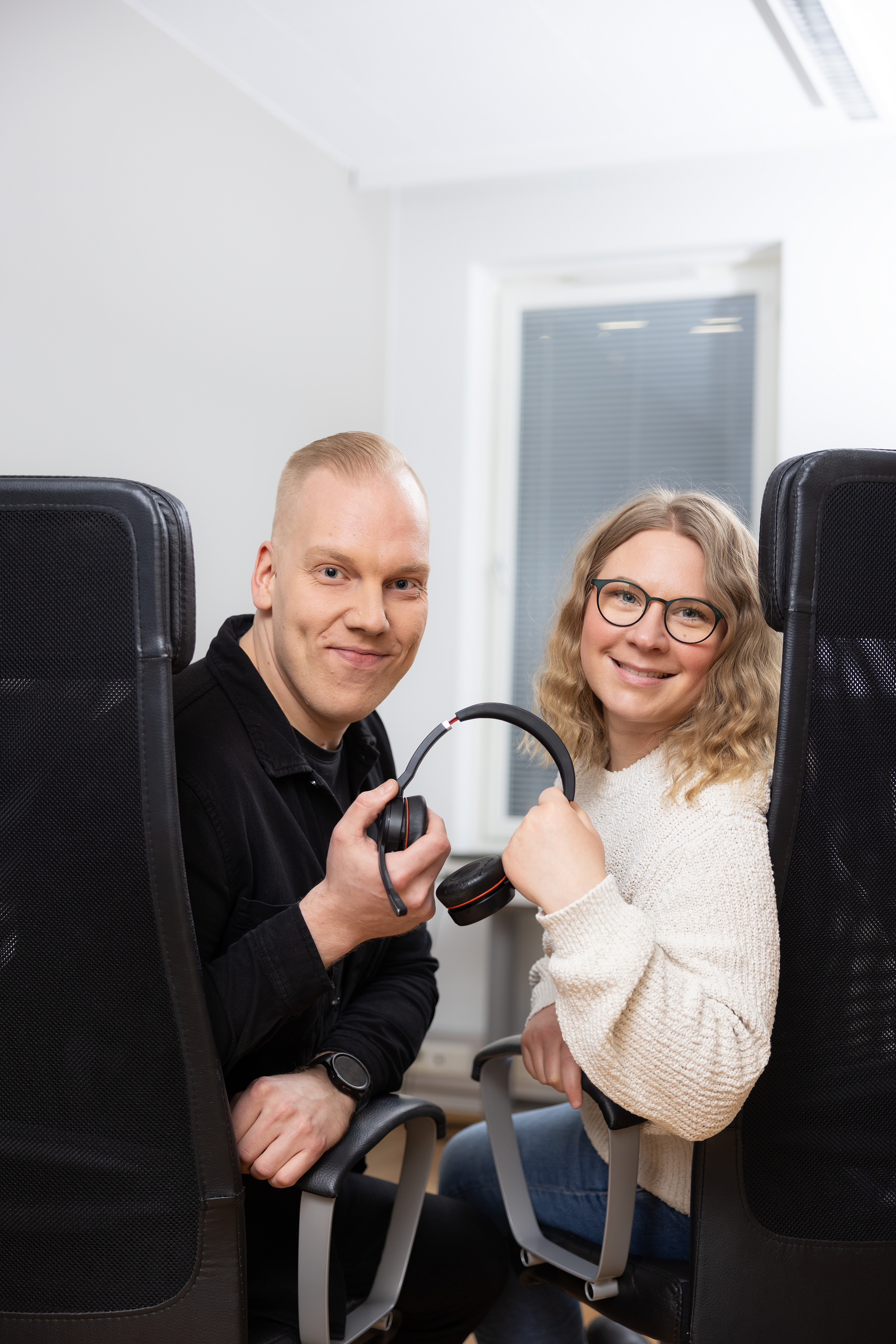 Två leende servicehandledare tittar in i kameran